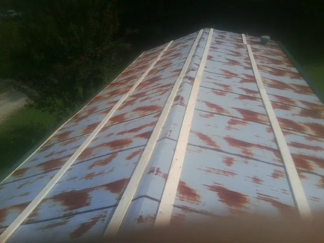 Rusted metal roof panels with new wood purlins before replacement — Storm Damage Roof Repair in Standish by Roofing Brothers