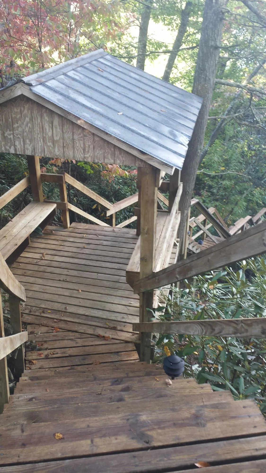 Metal roofed shelter over wooden steps on a wooded walkway — Skylight Repair & Installation work by our crew in Standish